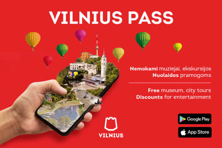 A person holding a phone with the word vitus pass on it while standing near a hot air balloon.
