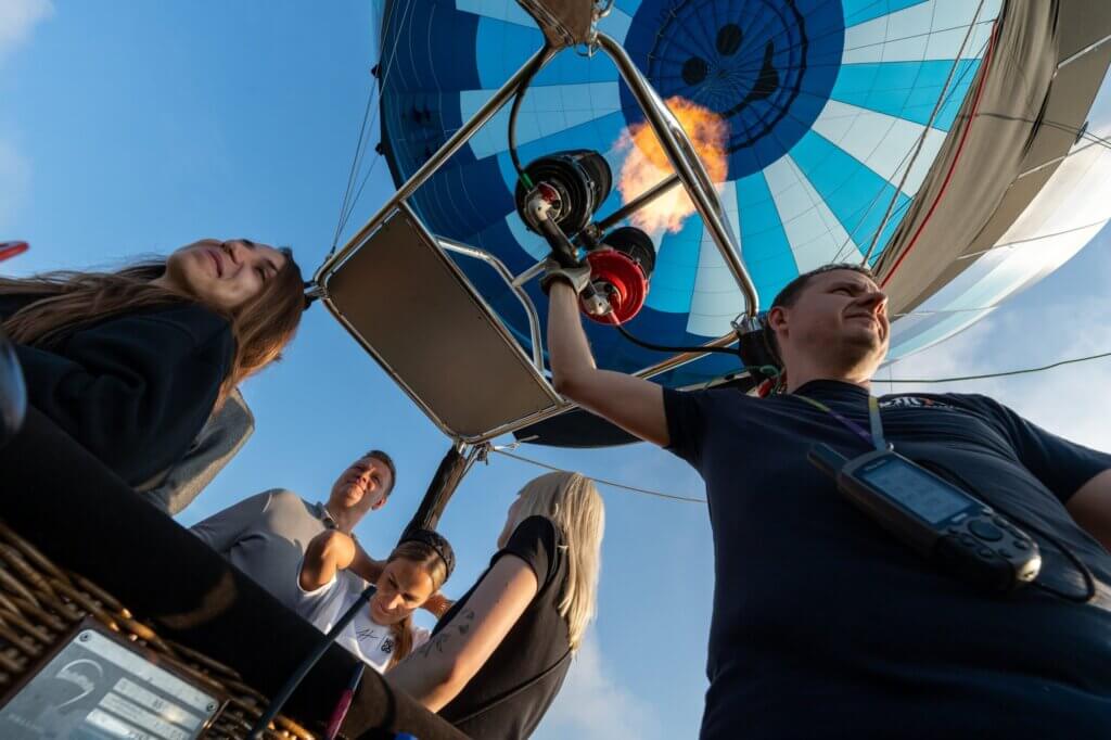 A group of people enjoying ballooning in a hot air balloon.