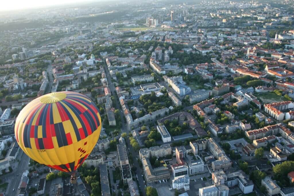 A hot air balloon soaring above a bustling city.