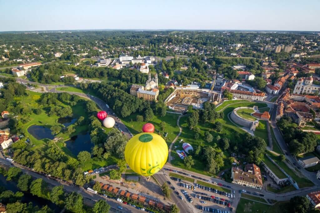 Aerial view of hot air balloons flying over a town.